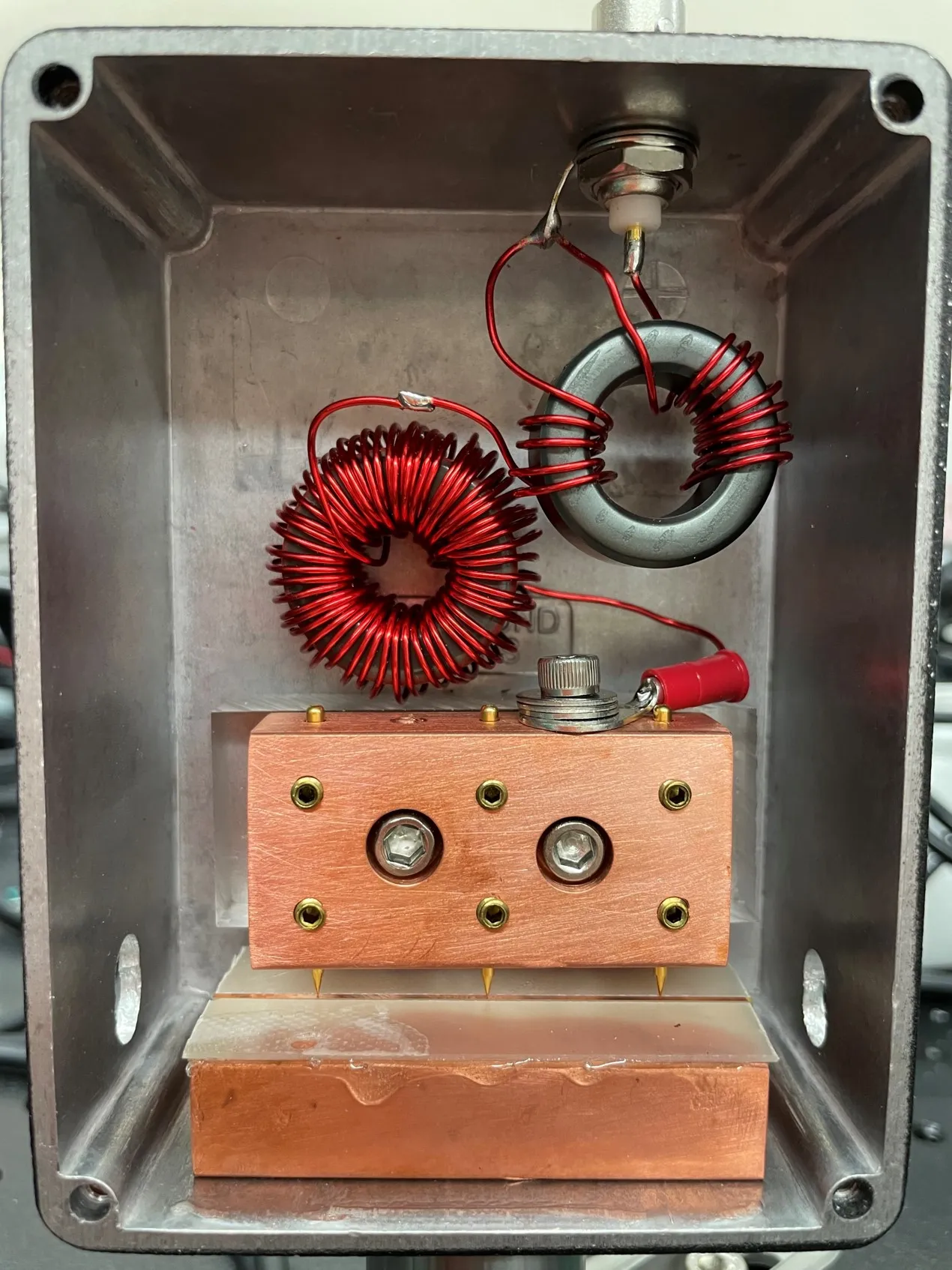 A hand-wound resonant electro-optic modulator — copper toroidal inductors and a copper crystal housing in a cast-aluminum enclosure.