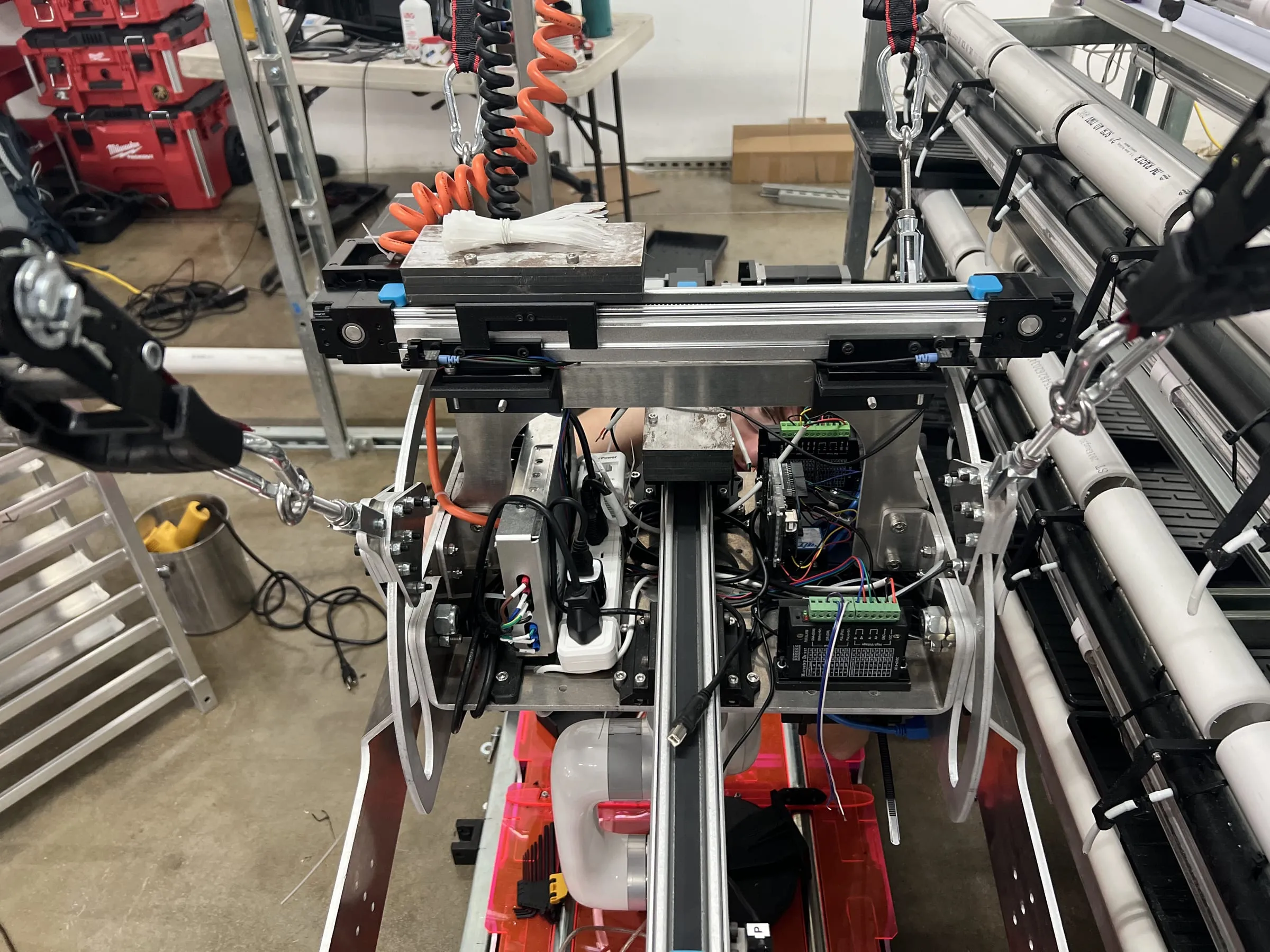 The inertial-dampening head on the bench — weights driven along a linear rail by a PID loop reading an IMU, cancelling the sway the robot induces whenever it moves a tray.